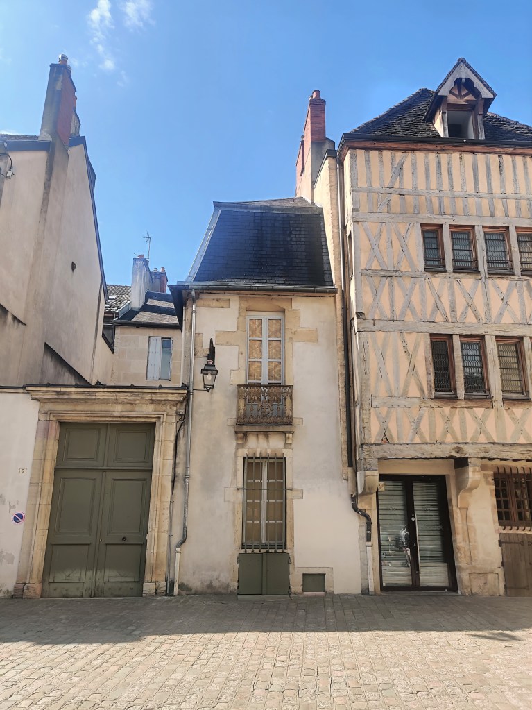 Yellowed buildings in Dijon, France, including a half-timbered house